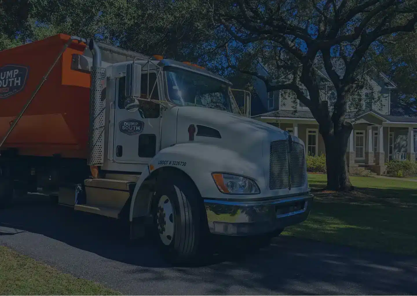 Dump South Dumpster truck in front of a Residential Property