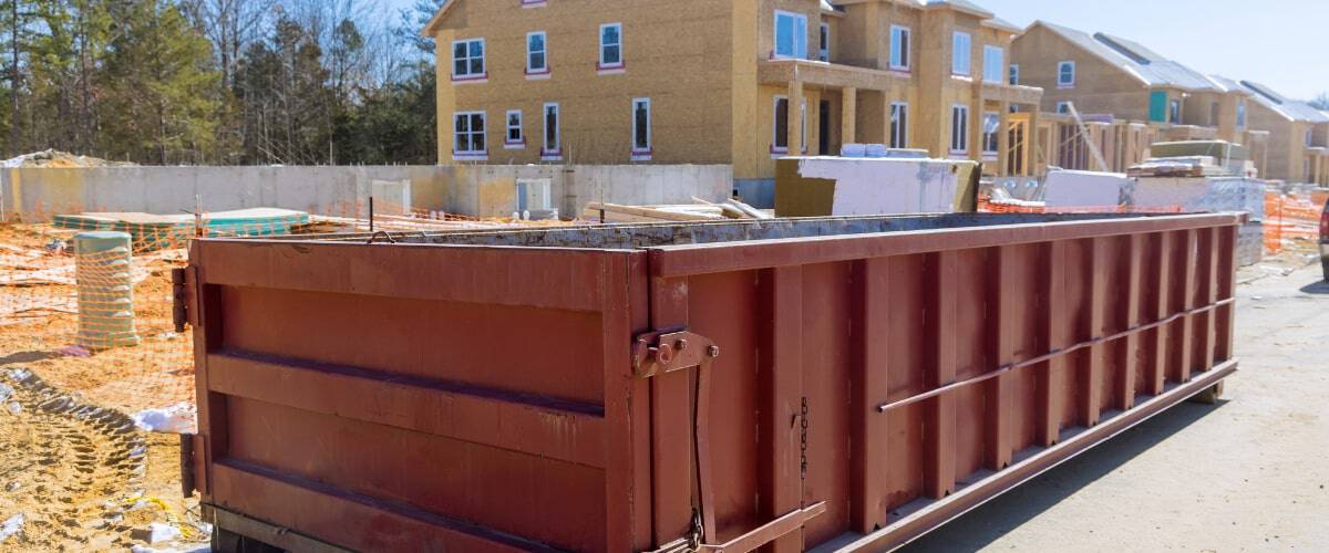 Construction site features large dumpster near new residential homes under development