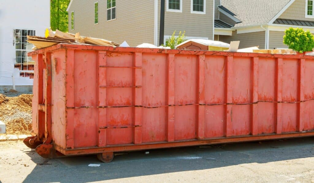 Large orange dumpster filled with debris