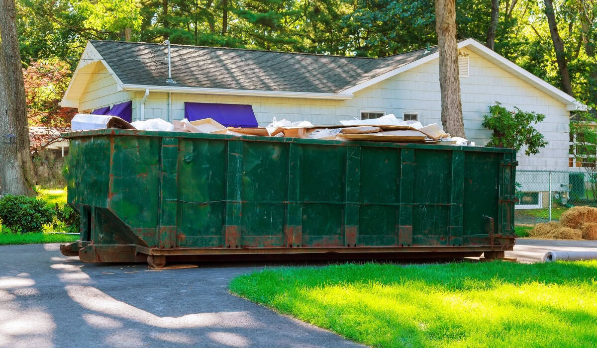 Large green dumpster filled with debris