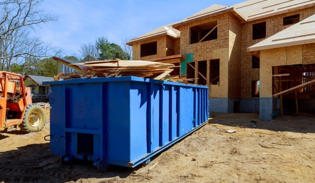 Construction site with blue dumpster nearby